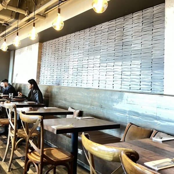 Surisan's dining area with patrons seated at tables, illuminated by hanging Edison bulbs.