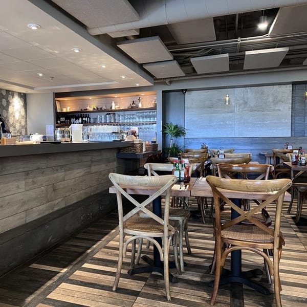 The interior of Surisan restaurant, featuring wooden tables and chairs, a bar area, and modern decor.